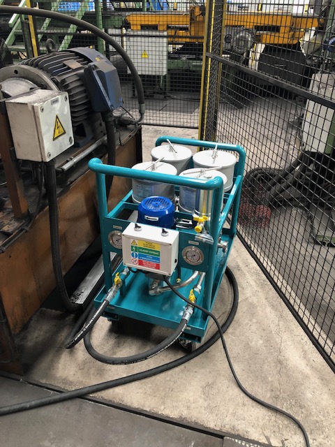 Mobile oil filtration unit beside industrial equipment