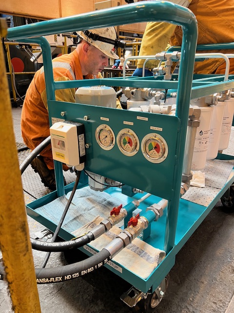 Technician operating a mobile oil filtration unit