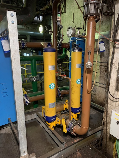 Two vertical oil filters installed on industrial piping
